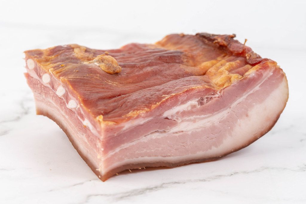 Raw homemade pork bacon on the white marble board (Flip 2019) (Flip 2019) (Flip 2019)