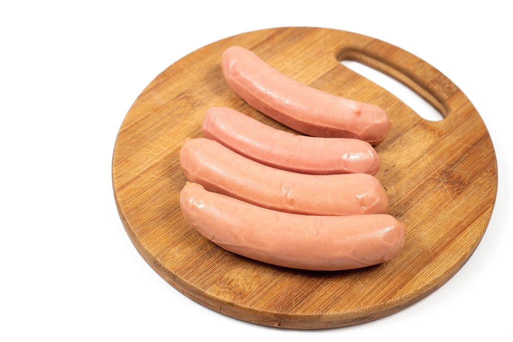 Raw Sausages on the round wooden board