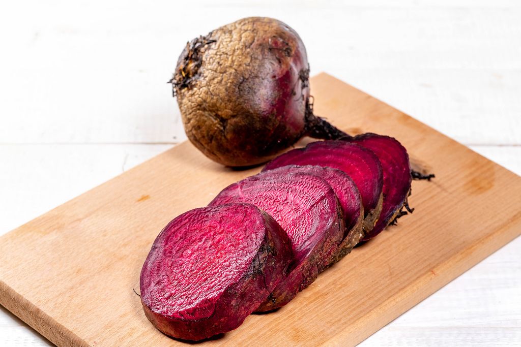 Red beet roots on kitchen board