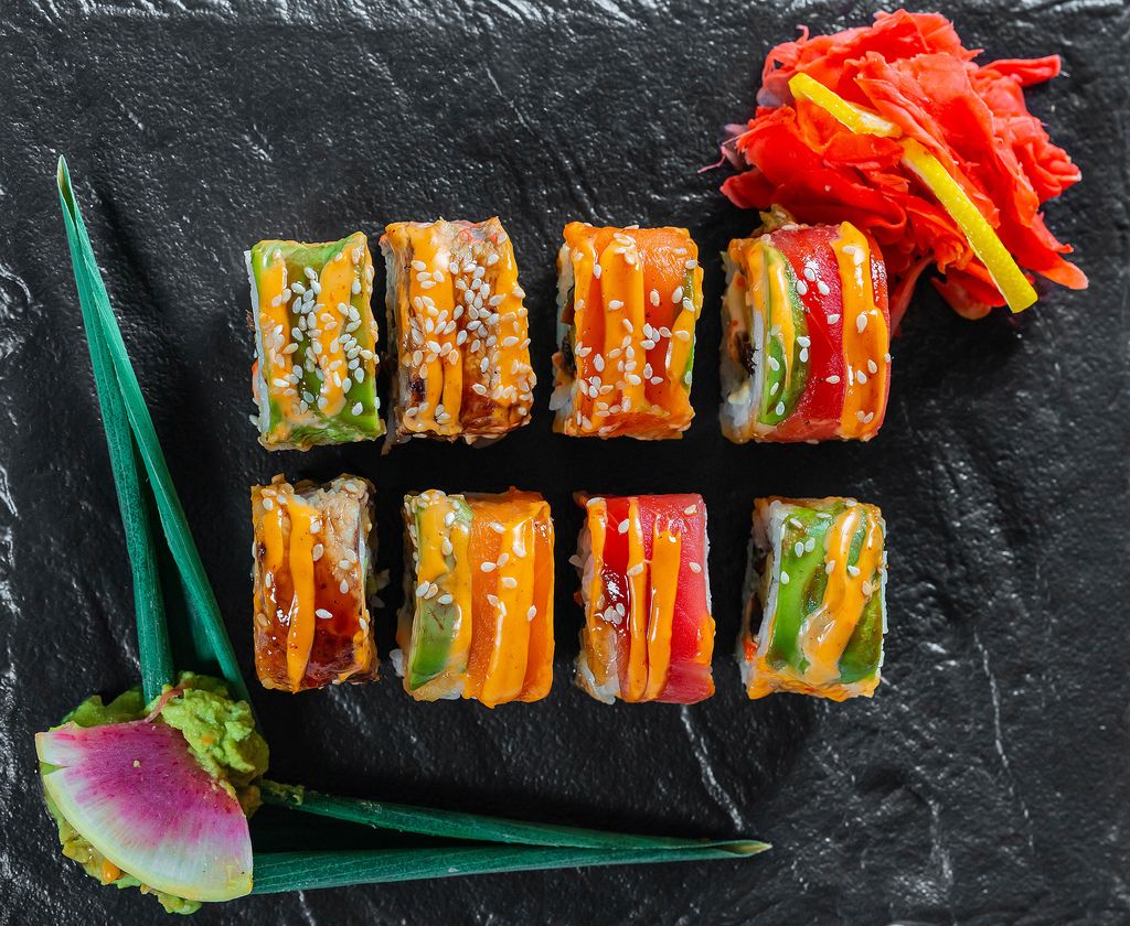 Regenbogen-Drachen-Sushi in mundgerechten Stücken mit Wasabi und eingelegtem Ingwer