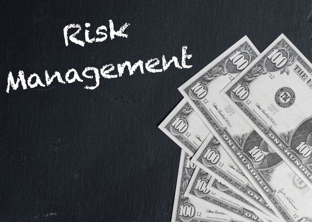 Risk Management text with US dollar banknotes
