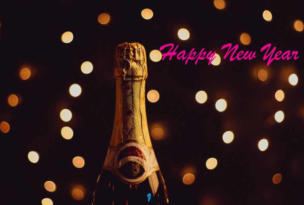 Rosaroter Text HAPPY NEW YEAR mit Champagner vor Bokeh Lichteffekten