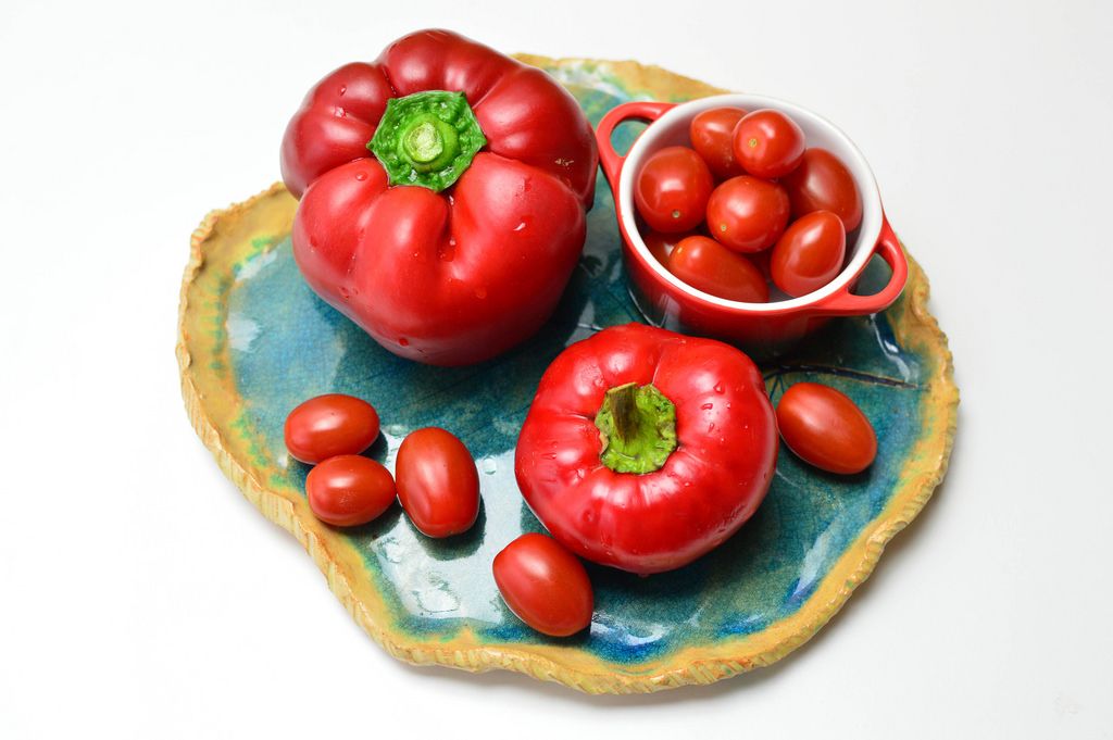 Rotes Gemüse - Rote Paprika mit Kirschtomaten auf blauem Tonteller ...