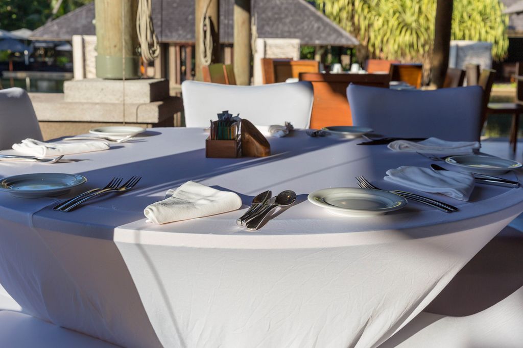 Runder, gedeckter Tisch in weiß mit Stoffservietten auf der Restaurantterasse im Constance Ephelia Resort auf Mahé, Seychellen