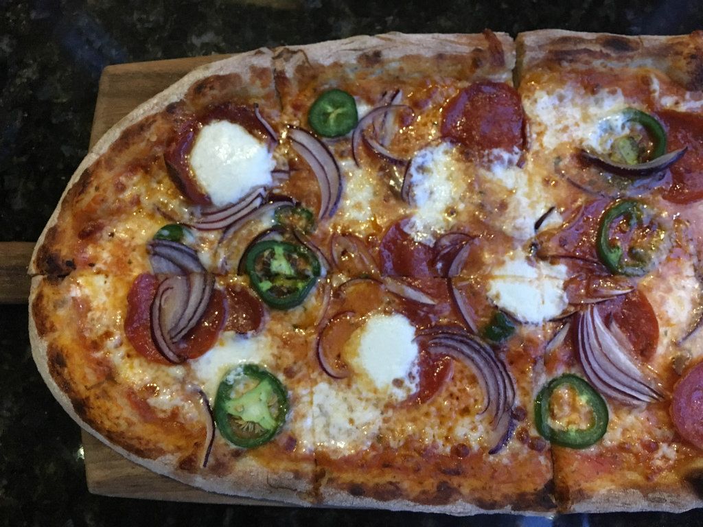 Rustikale Pizza mit Mozzarella, Paprika, Zwiebeln und Salami in Washington, USA