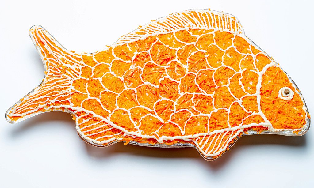Salad layers in the shape of a fish on a white background (Flip 2020)
