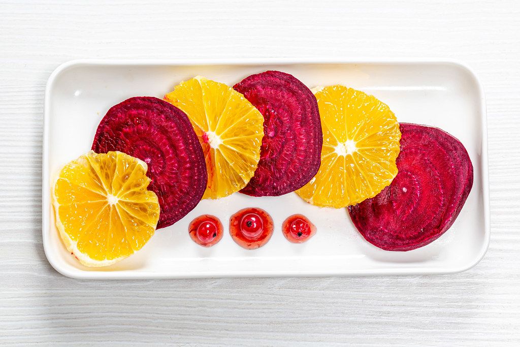 Salad with beets and oranges and berry sauce with red currants. Top view