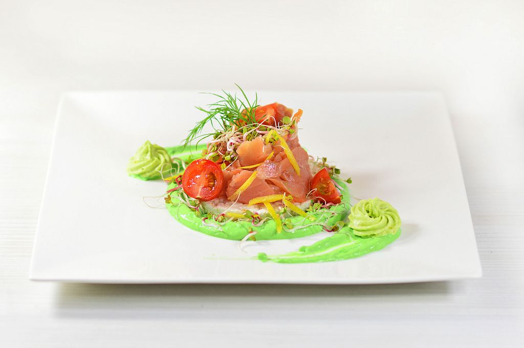 Salmon with radish sprouts, tomatoes and avocado paste