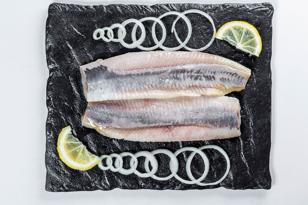 Salted herring with onion slices and lemon slices