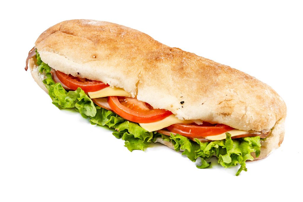 Sandwich mit Salatblätter, Tomatenscheiben, Käse und Schinken vor weißem Hintergrund