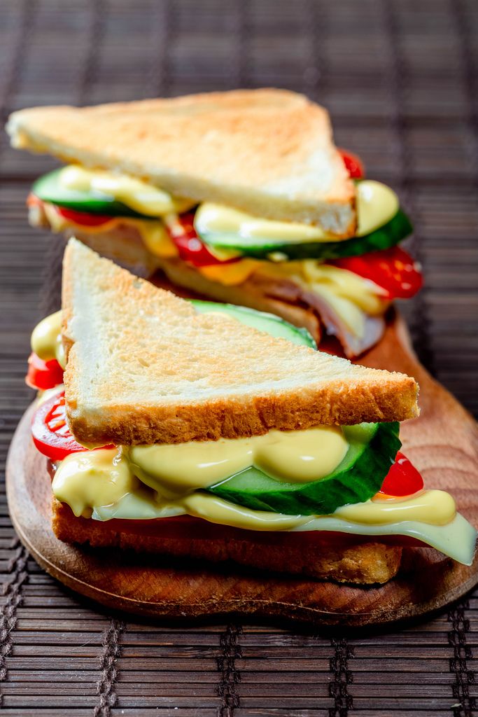 Sandwiches dreieckig mit Schinkenkäsetomaten-Salat und geröstetem Brot