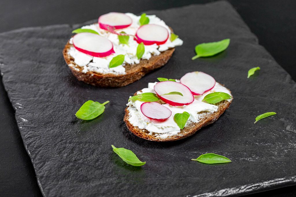 Sandwiches with cheese, radish slices and Basil leaves on a black background (Flip 2019)