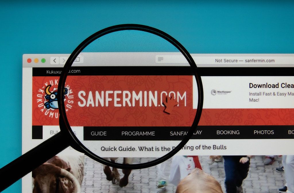 Sanfermin logo on a computer screen with a magnifying glass