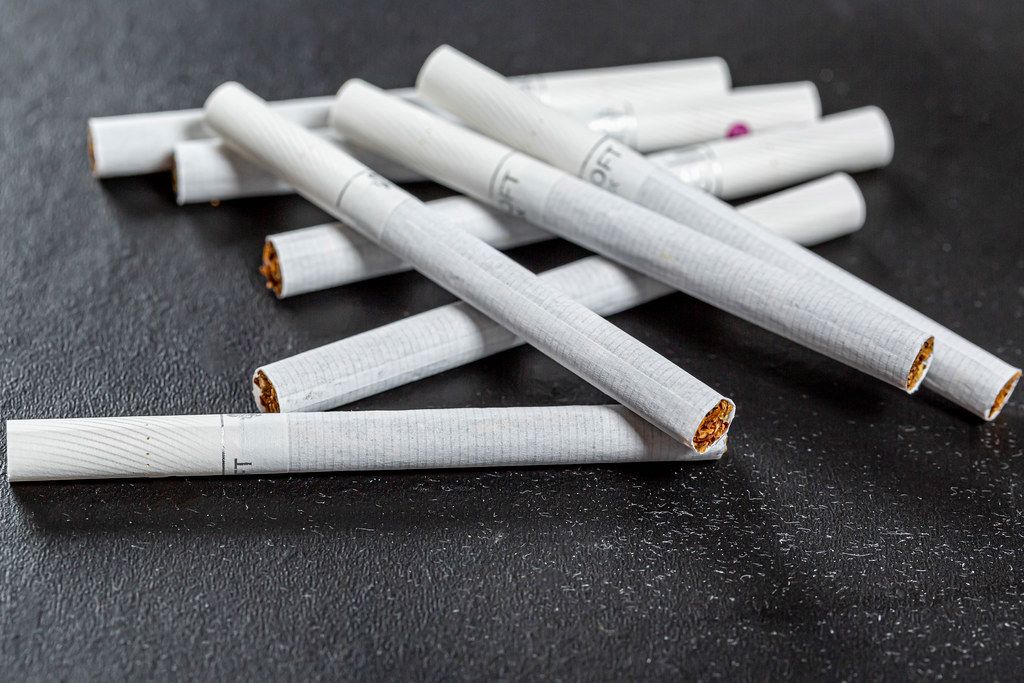 Scattered cigarettes on a black background, the concept of harm to health