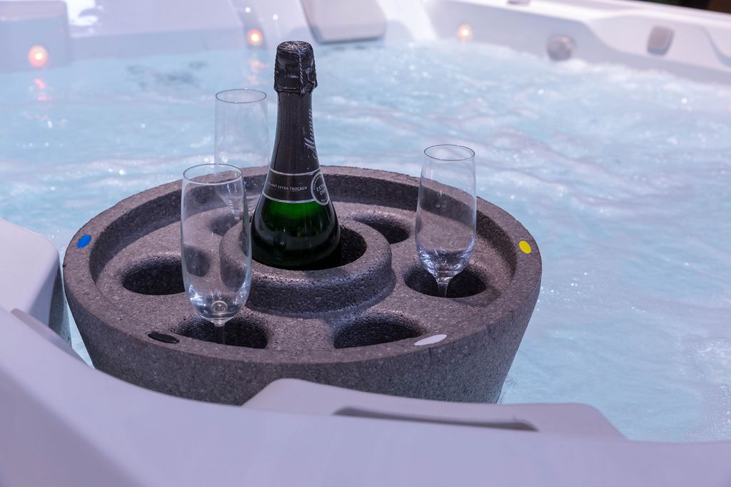 Schwimmende Insel mit Champagnerflasche und Platz für sechs Gläser in Whirlpool