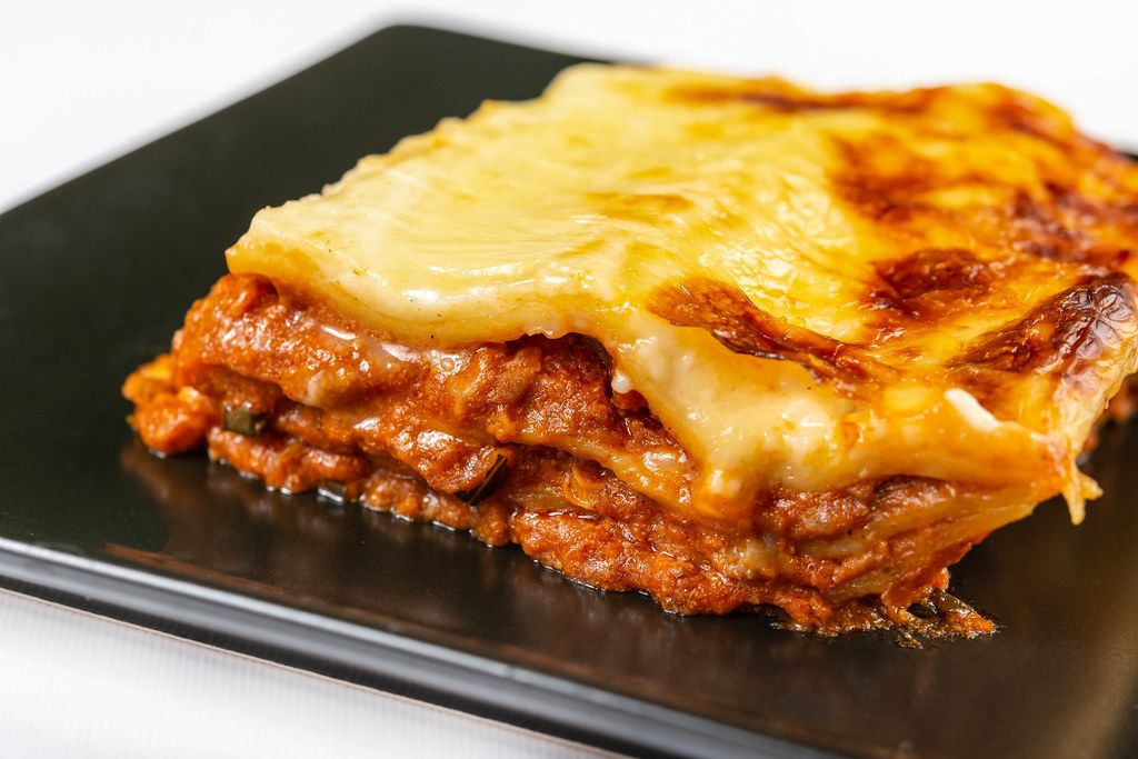 Served Lasagna on the black square plate