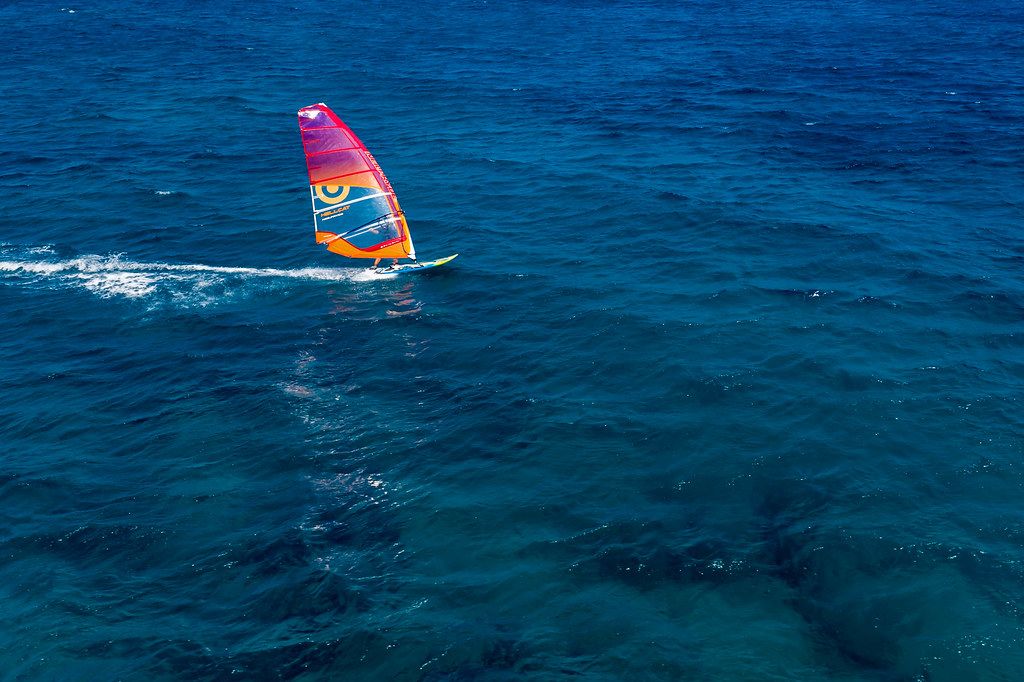 Single windsurfer doing watersports in the deep blue Aegean Sea