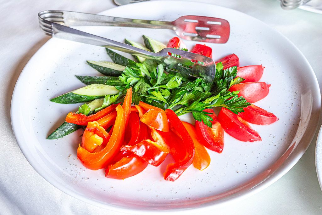 Sliced fresh tomatoes, cucumbers and bell peppers and parsley on a plate (Flip 2019)