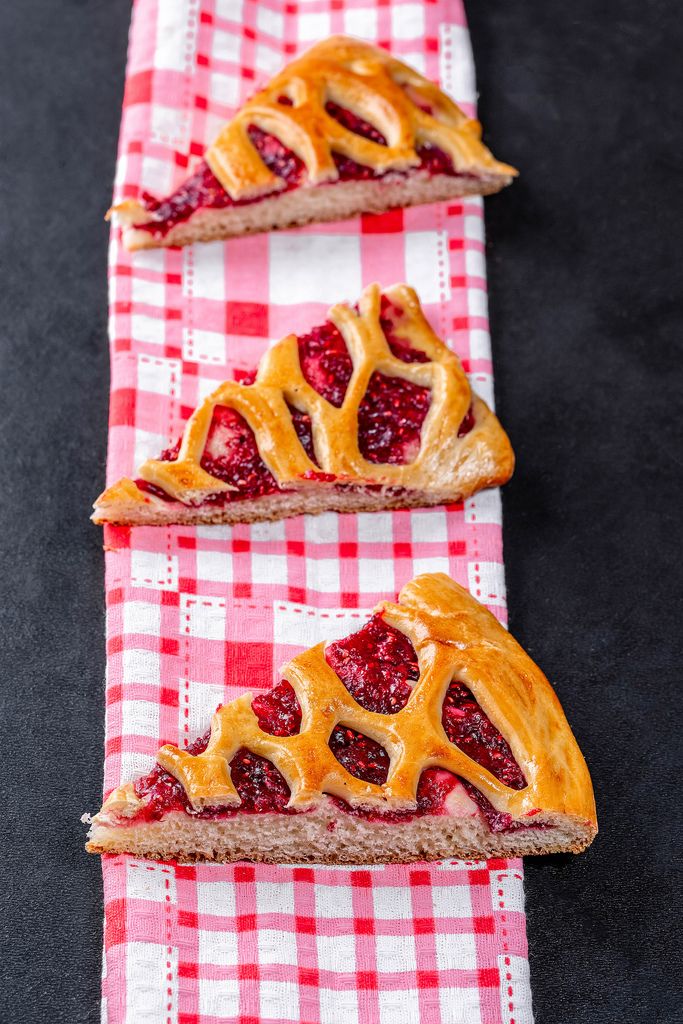 Sliced pieces of cake with raspberry jam on a dark background