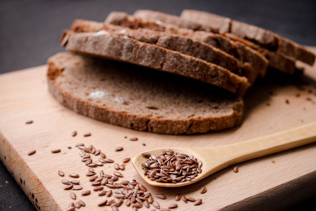 Slices of  dark  fresh bread with  seeds on dark wooden background
