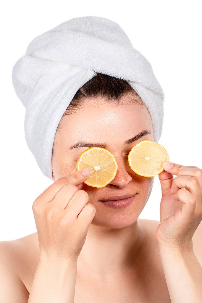 Slices of lemon in the hands of a girl in front of her eyes
