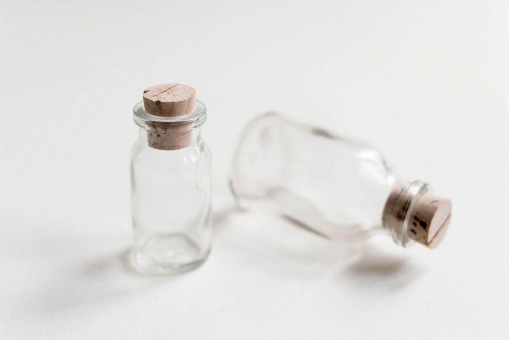 Small bottles with cork cap on white background