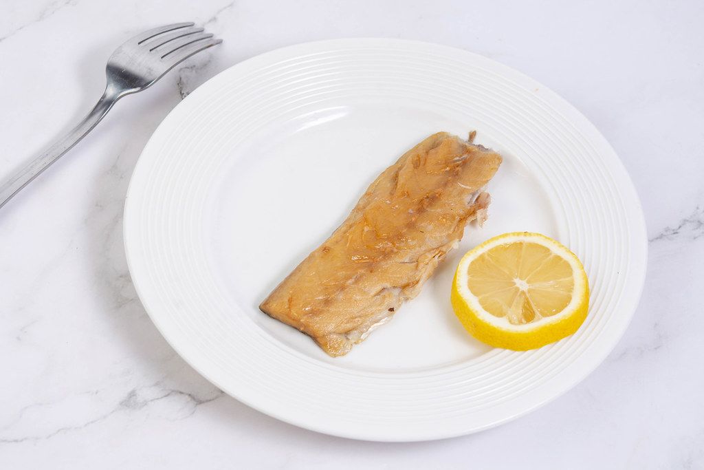 Smoked Mackerel fish with Lemon on the white plate