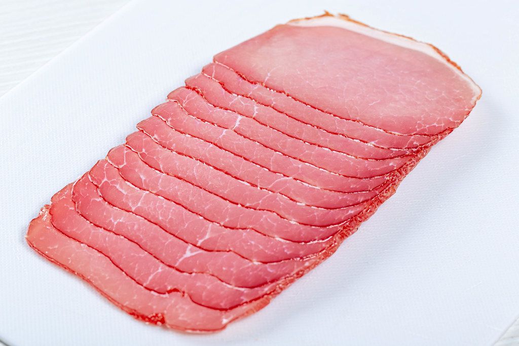 Smoked pork ham sliced on the slicer