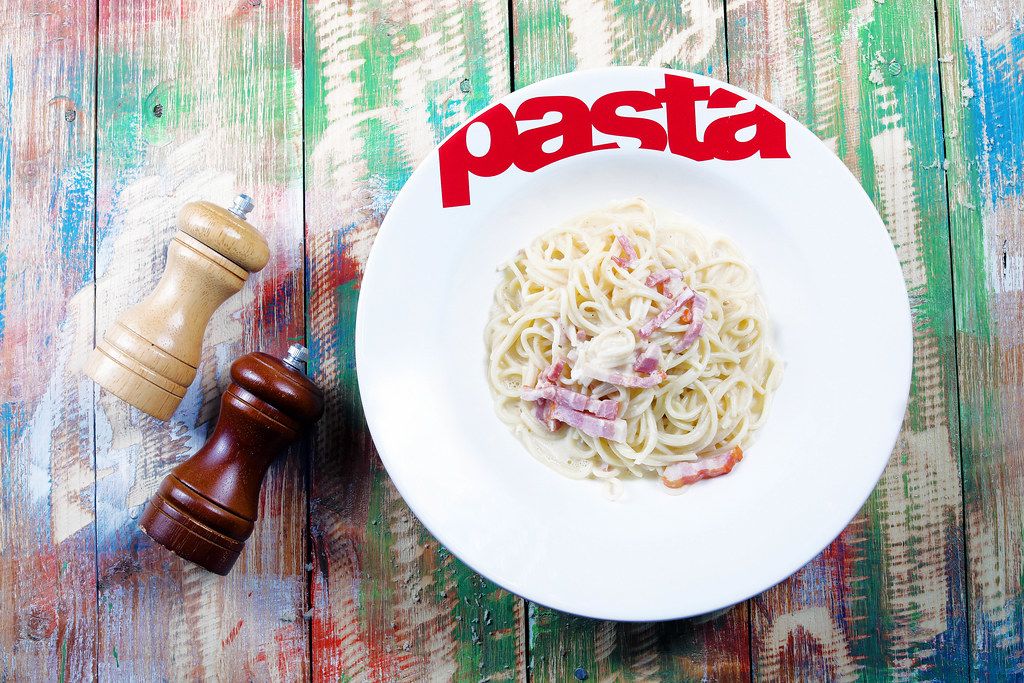 Spaghetti carbonara with bacon and parmesan, pasta plate, wooden background