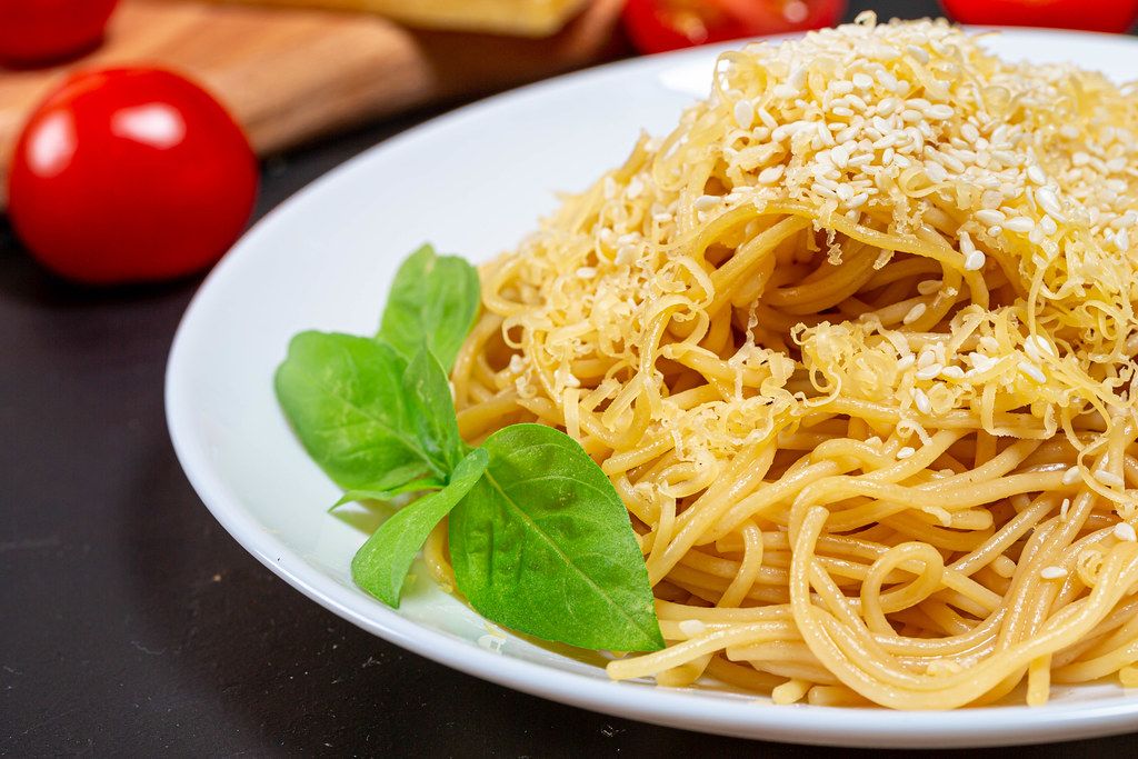 Spaghetti with grated cheese and sesame seeds close-up (Flip 2019)