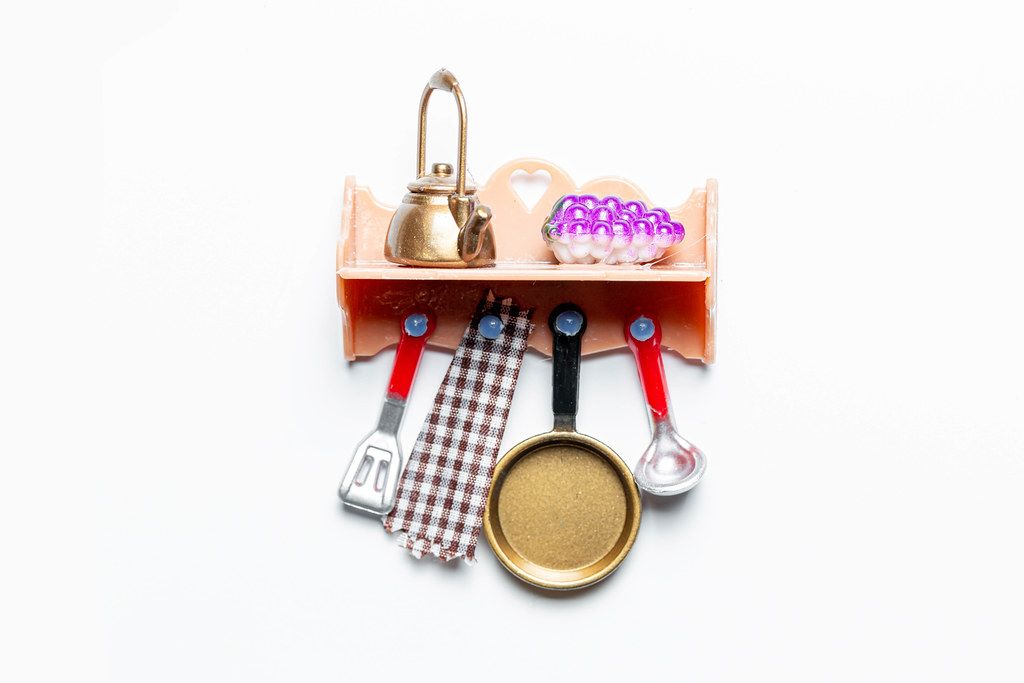 Spielzeug Küchenregal mit Küchenutensilien auf weißem Hintergrund