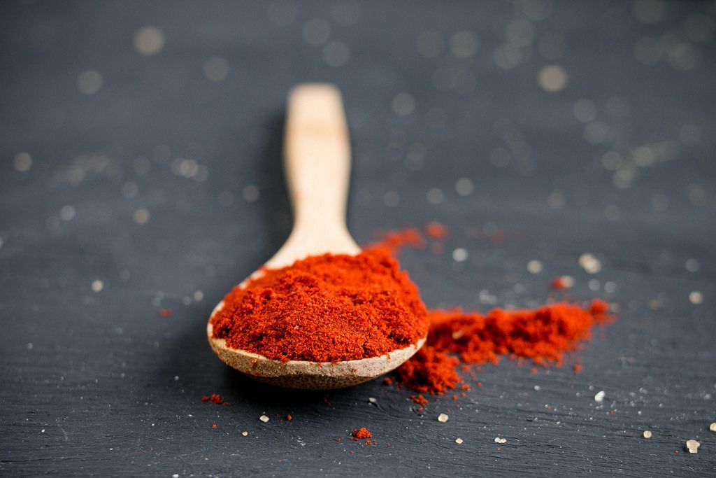 Spoon with paprika powder and chili pepper