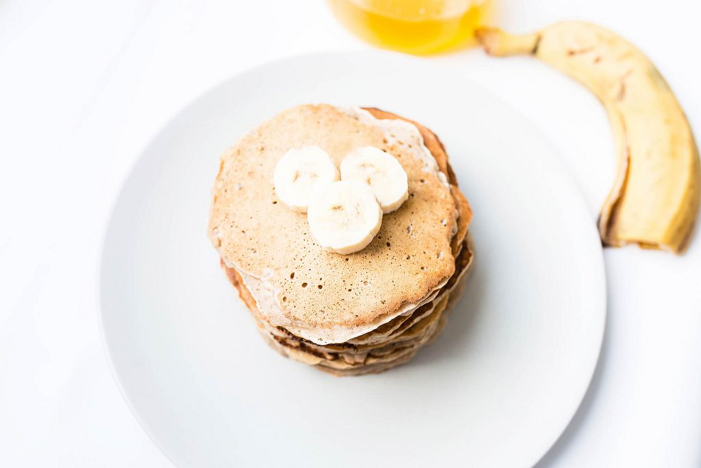Stack of banana pancakes in a plate on white background (Flip 2019) (Flip 2019) Flip 2019