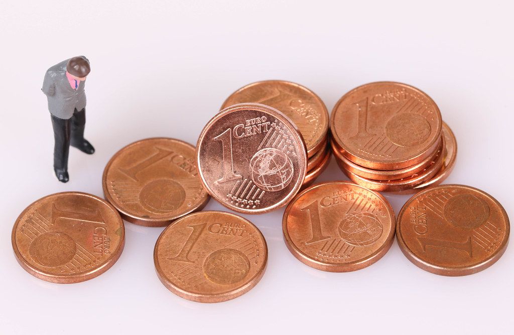 Stacks of One Euro cent coins with businessman on white background