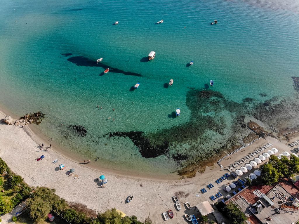 Strand in Afitos und anlegende Boote. Luftbild
