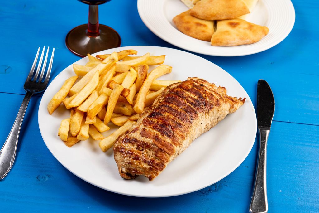 Stuffed pork Steak meat and French Fries on wooden table