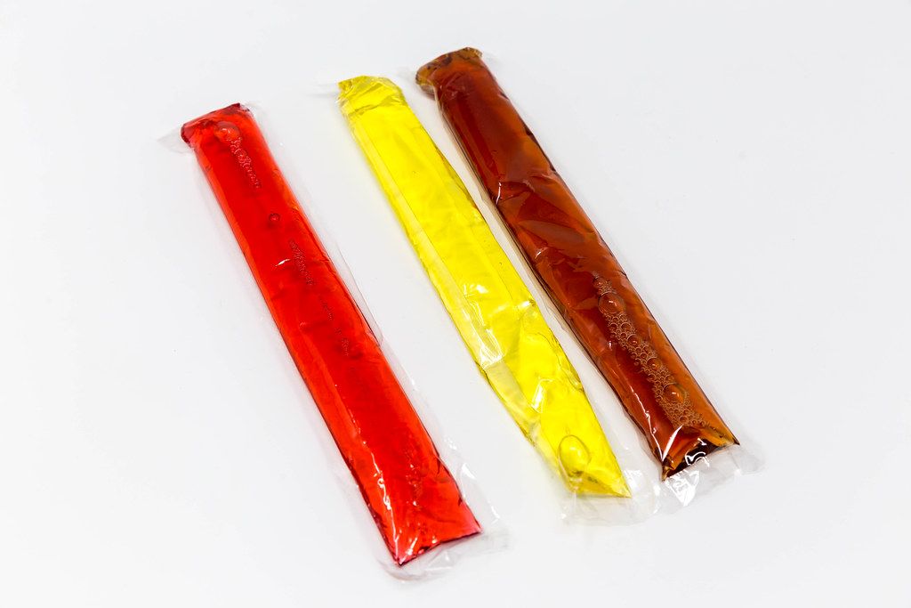 Summer vibes: three ice lollies in different colours and flavours on a white background