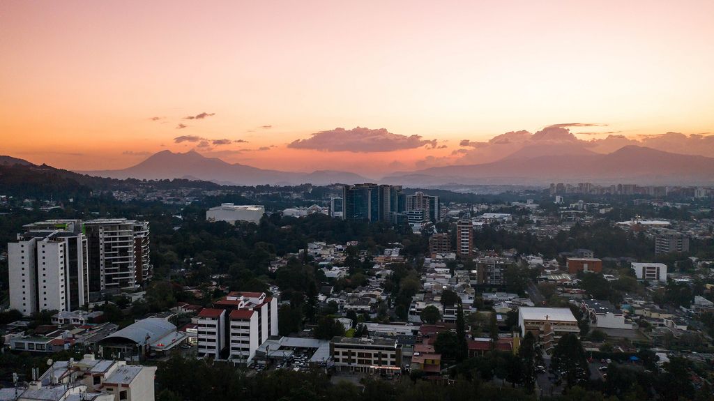 Sunset over Guatemala City Buildings over the Volcanoes on the Horizon.jpg