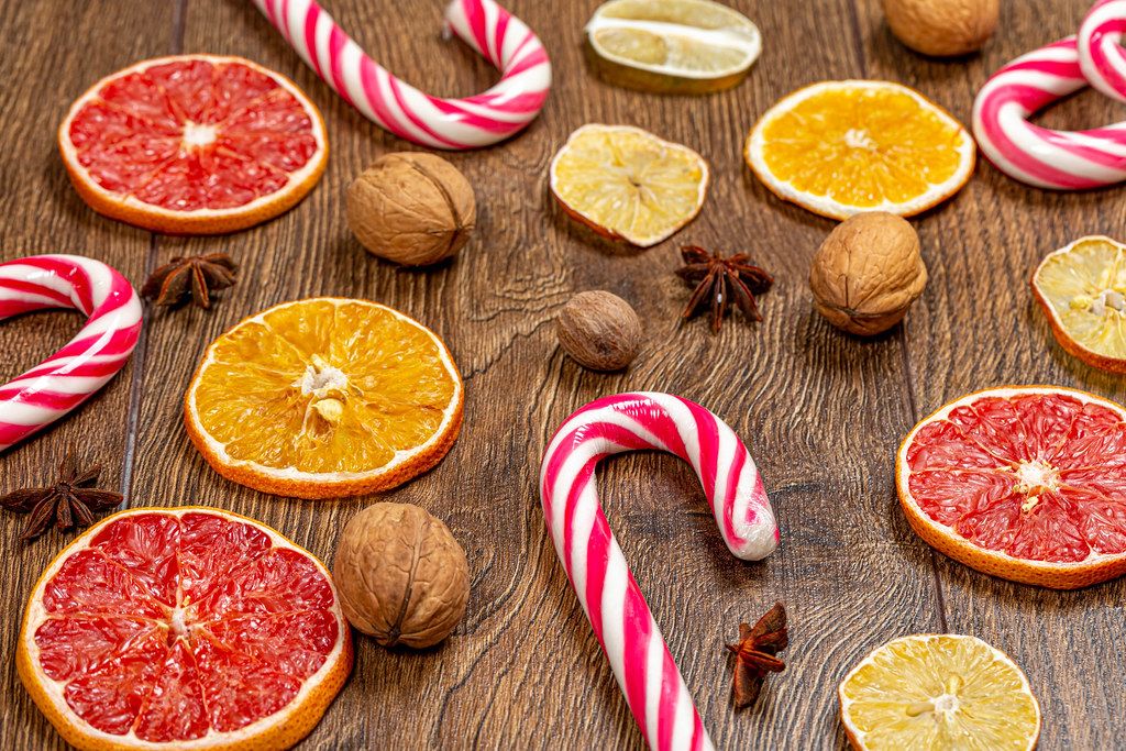 Sweet Christmas cane-lollipops with pieces of dried citrus and nuts (Flip 2019)
