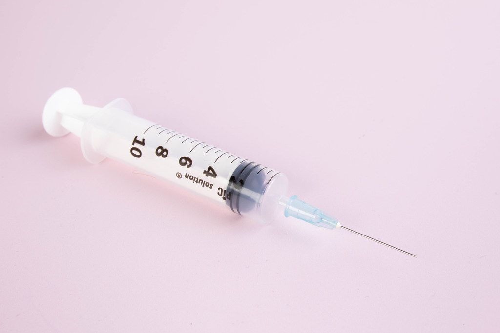 Syringe on pink background