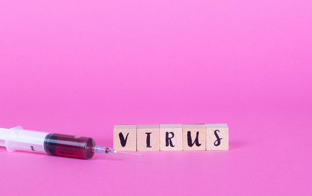 Syringe with wooden blocks and word Virus