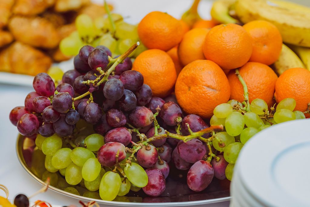 Teller mit frischen Weintrauben und Mandarinen