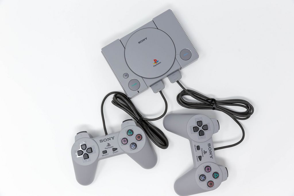 The Sony Playstation Classic mini console with two controllers on white background  - top view