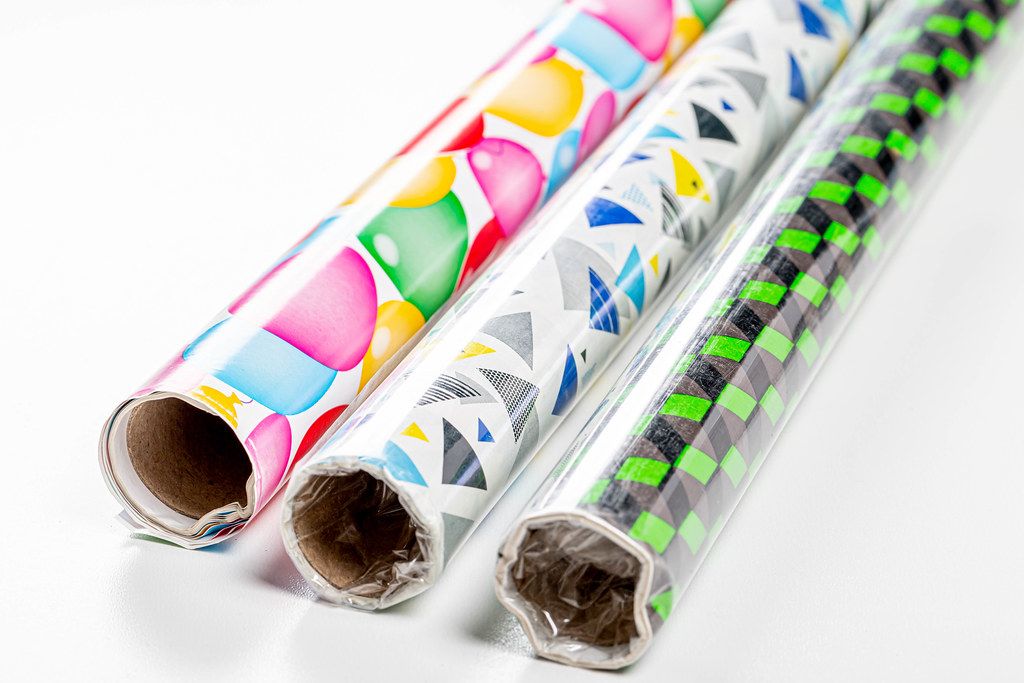 Three rolls of multi-colored gift wrapping paper