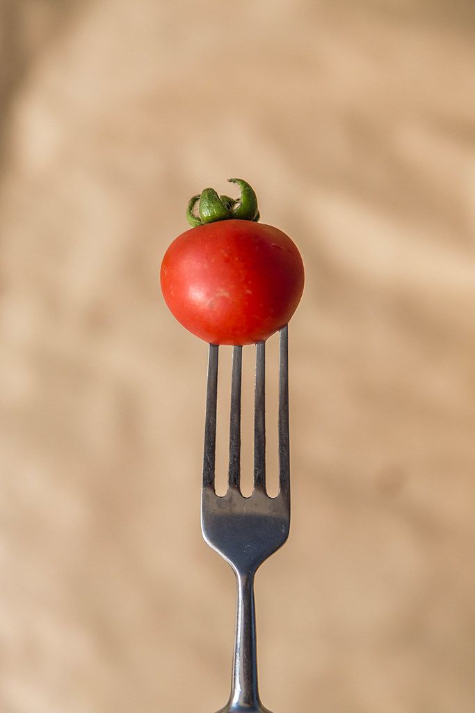 Tomato on fork. Vetical photo. (Flip 2019)