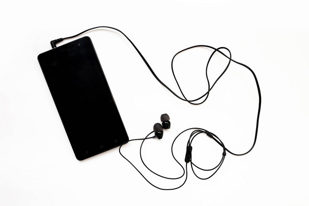 Top view of black smartphone connected with earphones isolated (Flip 2019) (Flip 2019) Flip 2019