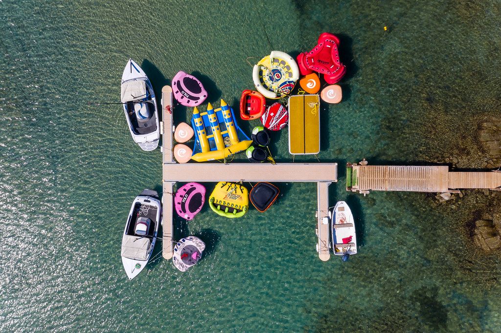 Top view of colourful rubber dinghies and water toys at Kolimbithres Beach on Paros, Greece