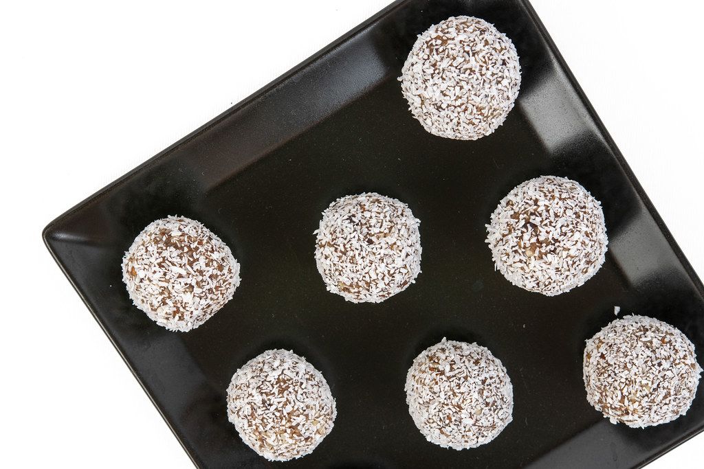Top view of Energy Balls with Almonds Walnuts and Coconut on the black plate