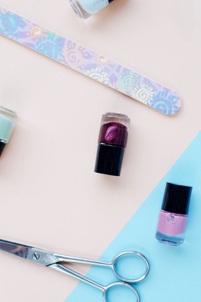 Top view of flat lay with nail polish and manicure accessories. Colorful background.