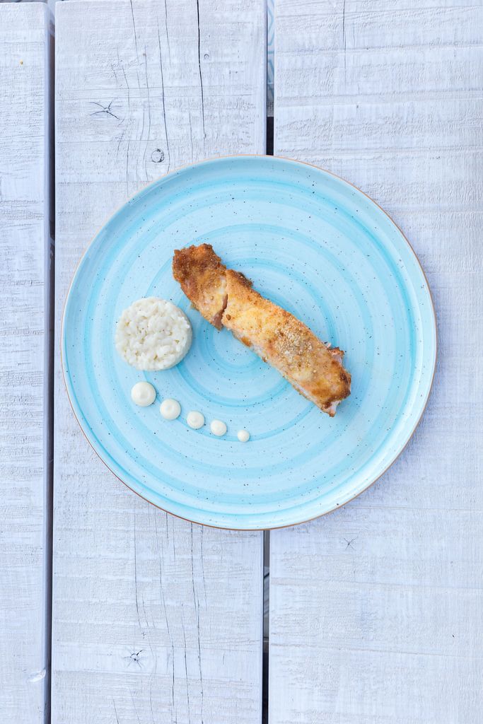 Top view of gratinated salmon with parmesan crust, dark rice and wasabi mayonnaise